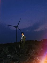 Man standing on rock against sky