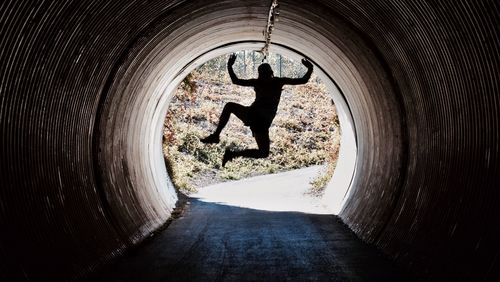 Silhouette man in tunnel