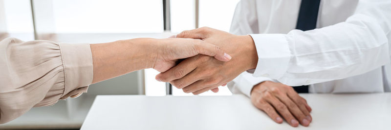 Midsection of business people shaking hands