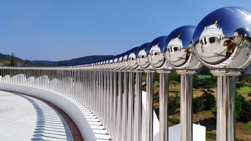 Reflection of built structure in water against clear blue sky