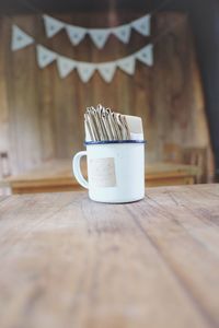 Napkins in coffee cup of wooden table at home