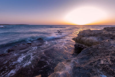 Scenic view of sea against clear sky during sunset