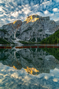 Scenic view of lake by snowcapped mountains against sky