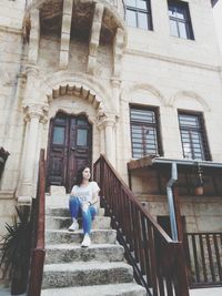 Full length of woman standing against building