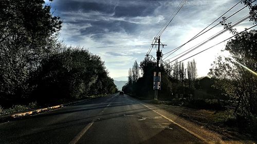 Road amidst trees against sky