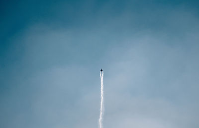 Low angle view of airplane flying against sky