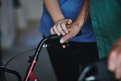 Midsection of man holding bicycle