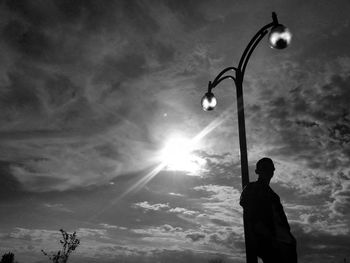 Man with umbrella against sky