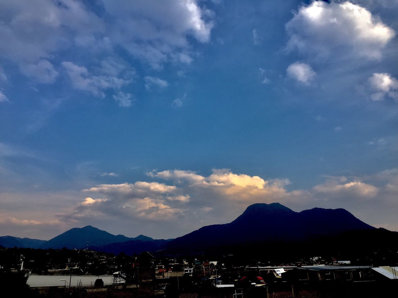 sky, cloud - sky, mountain, mountain range, travel destinations, beauty in nature, built structure, scenics, architecture, outdoors, building exterior, nature, no people, cityscape, day