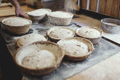 Close-up of fresh baked food in wicker basket on table at bakery