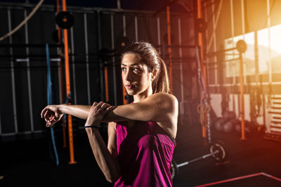 Side view of young woman exercising in gym