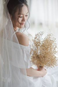Smiling bride holding bouquet