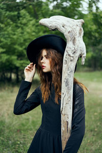 Rear view of woman standing against trees