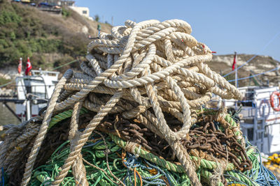 Close-up of rope tied to fishing net at harbor