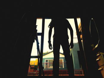 Silhouette man standing by window in building