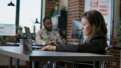 Young woman using laptop at cafe