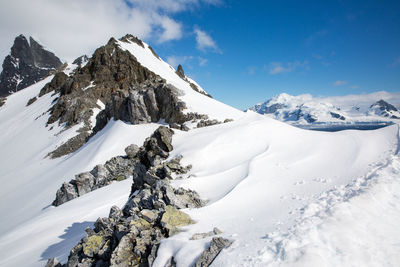 Scenic view of snow covered mountains against sky