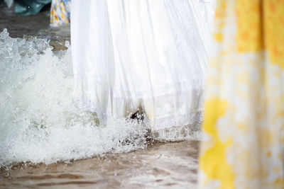 People entering the sea water wearing long dresses.