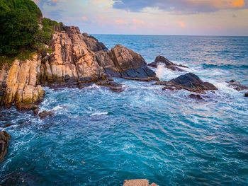 Scenic view of rocks in sea against sky