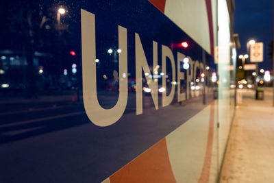 Close-up of illuminated text on road at night