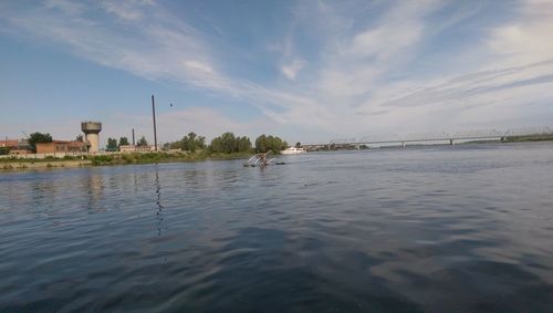 Scenic view of river against sky in city