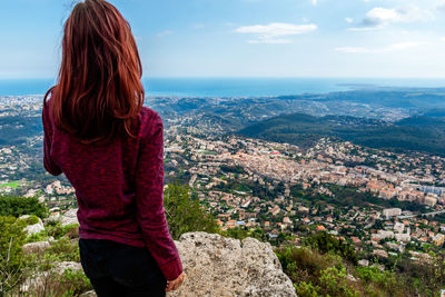 Rear view of woman looking at landscape against sky