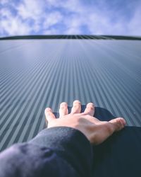 Close-up of hands against sky