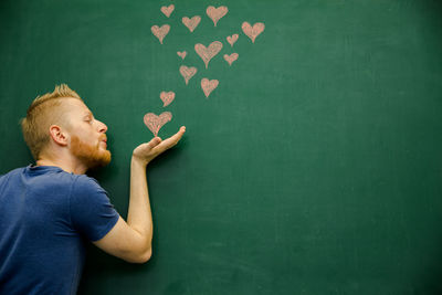 Young man standing against wall