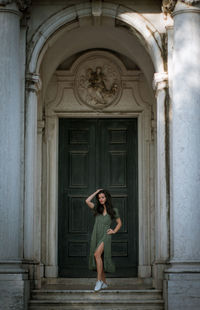 Full length of woman standing on steps against building