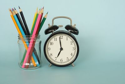 Close-up of clock on table against white background