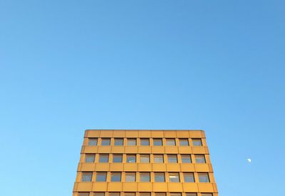 Low angle view of buildings against clear blue sky