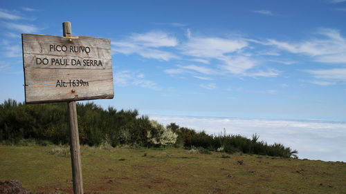 Information sign on land against sky