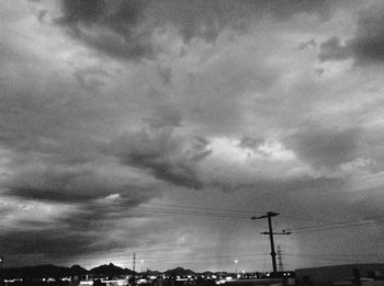 Low angle view of silhouette electricity pylon against sky