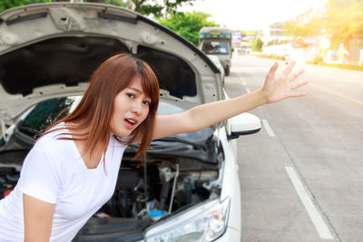 Portrait of woman in car on road in city