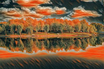 Reflection of trees in lake during sunset