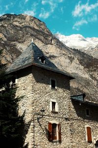 Low angle view of old house by mountain
