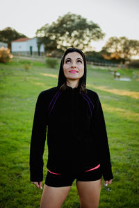 Portrait of beautiful young woman standing on grass