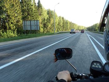 Vehicles on road against clear sky