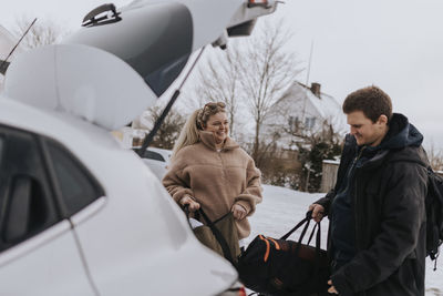 People packing bag in car after workout in gym