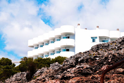 Low angle view of hotel by rocks against sky