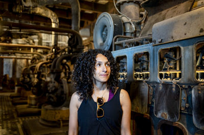 Portrait of young woman standing in factory