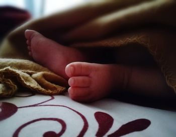 Close-up of baby hand on bed