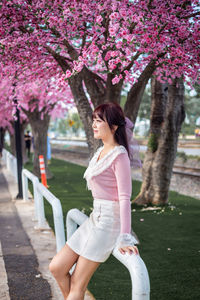 Full length of woman with pink flowers in park