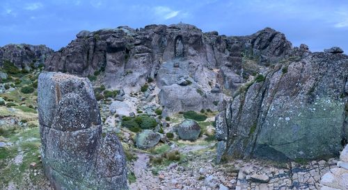 Rock formations on field against sky