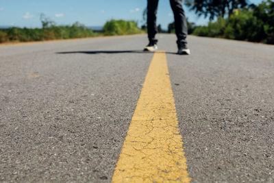 Low section of person standing on road