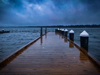 Wooden pier over sea against sky