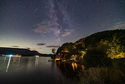 Scenic view of lake against sky at night