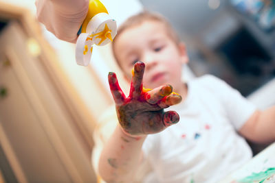 Close-up of messy child playing with paints