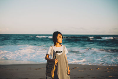 Man standing at beach against sky