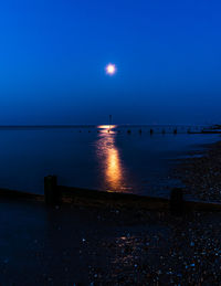 Scenic view of sea against clear sky at night